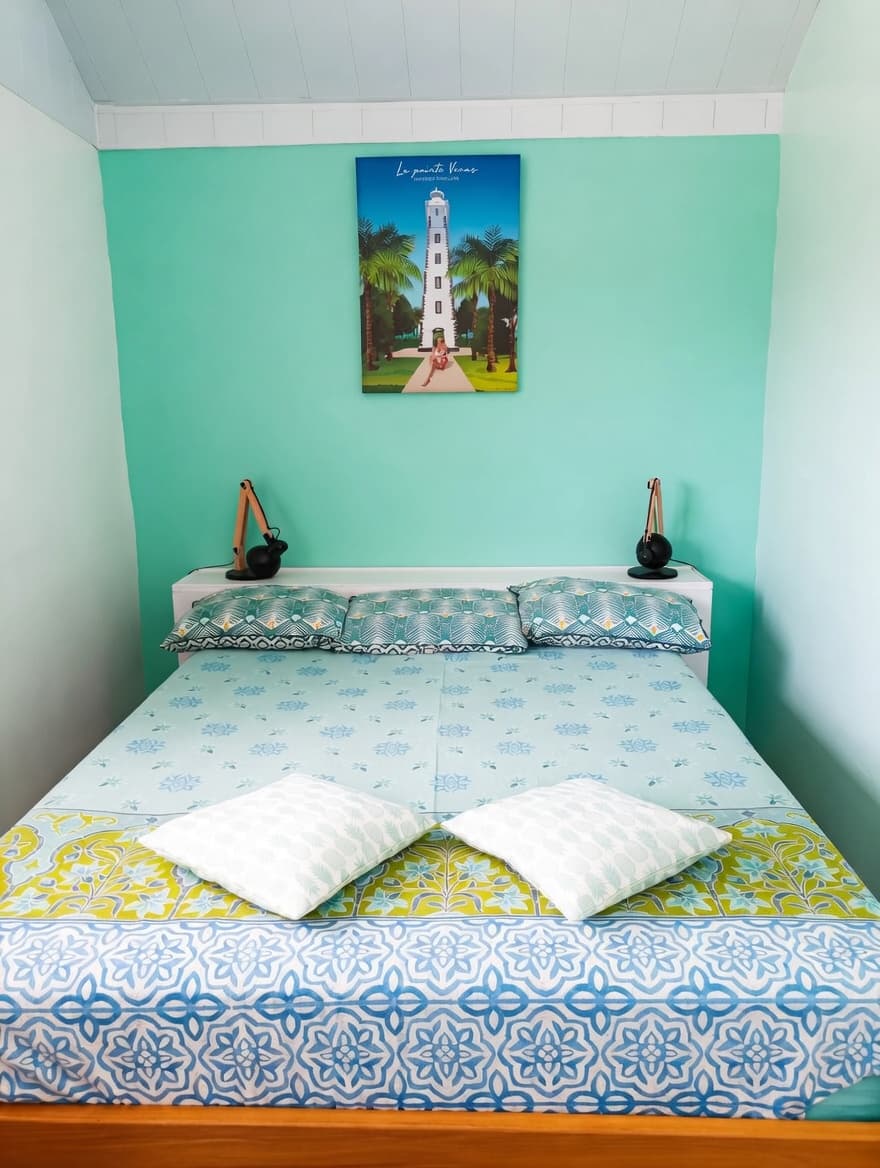 Chambre principale avec lit double et murs turquoise